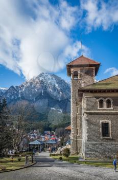 Cantacuzino Castle and the Carpathian Mountains in a sunny day. Residence and museum in a Transylvanian Busteni city, Romania