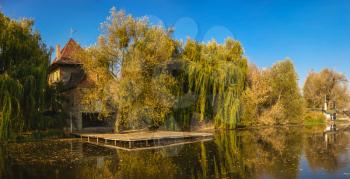 Autumn landscape with a lake and yellow trees in the village of Ivanki, Cherkasy region, Ukraine, on a sunny autumn evening