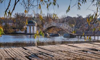 Bridge over the lake on a sunny autumn evening in the village of Ivanki, Cherkasy region, Ukraine