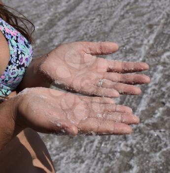 Salt on the girl's hands. Dried salt on the hands of women of the ancient lake.