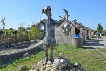 Metal statue of a Cossack holding a crane. Steel statue fantastic character.