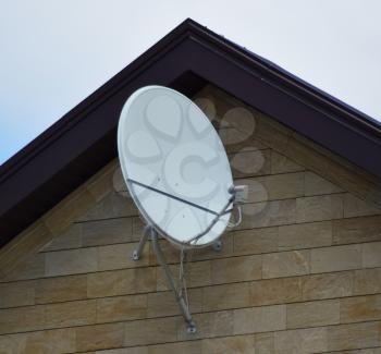 Satellite dish on the front of the house. Telecommunications.