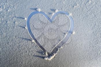 A heart drawn in the frost on the hood of the car.