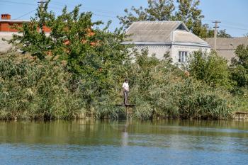 House by the river. Fishing near the house by the river, overgrown with reeds.