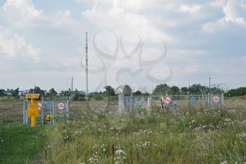 Russia, Slavyansk-on-Kuban - July 28 2015: Fencing valve closing the gas pipeline. On the fence there are signs warning about opastnosti and prohibit unauthorized entrance.