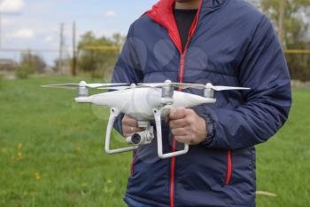 A man with a quadrocopter in his hands. A white drone is being prepared for the flight. Phantom