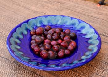 Berries of a sweet cherry in a blue plate. Ripe red sweet cherry.