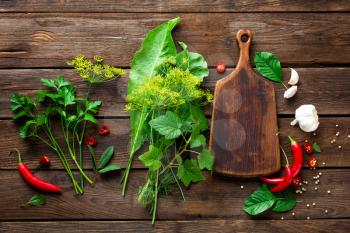 dark wooden culinary background with different herbs and spices, top view, rustic style