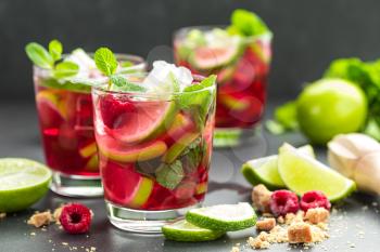 Raspberry mojito cocktail with lime, mint and ice, cold refreshing drink