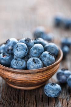 Fresh Blueberry in bowl on wooden background, closeup