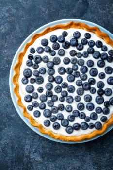 Delicious dessert blueberry tart with fresh berries and whipped cream, sweet tasty cheesecake, berry pie. French cuisine