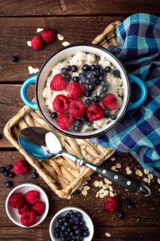 Oatmeal porridge with fresh berries, oats with blueberry and raspberry