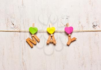 the word may  letters on a wooden clothespins on a white background old