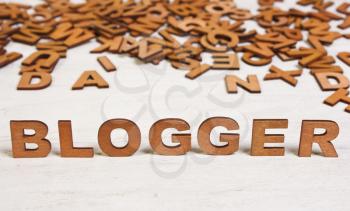 blogger word of wooden letters on a white background old wooden