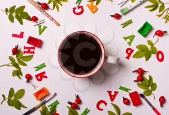 Colorful bright pattern of the brush, paint, leaves, red flowers with a cup coffee.Concept designer.Flat lay, top view