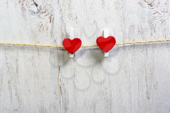 Double Red hearts hanging on the clothesline and white wood background.Valentine day.