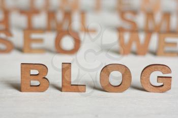 the word blog with wooden letters on a background of blurred letters,make a web site,blog