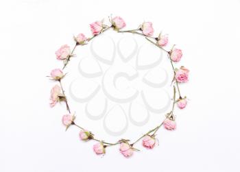 round frame of pink  flowers on white background.Pattern of red roses.Flat lay, top view