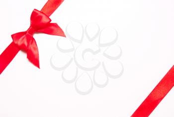 Red ribbons with bow with tails  on white background. The concept of gift, holiday