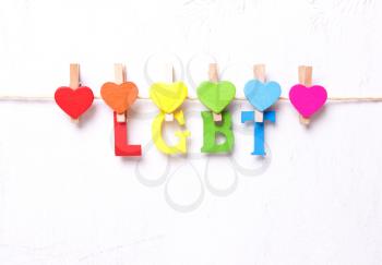 The word LGBT from multicolored letters on a white background, hearts in rainbow symbolism