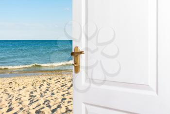 White doors Open  to the beach. Entrance, exit to the room, house to the sea. The concept of relaxation, vacation, a new life