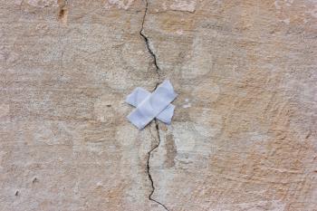 wall with a crack and a patch. Concept of repair, restoration, unification