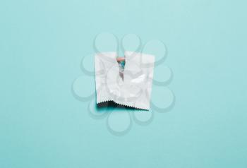 Condom on a blue background. The concept of safe sex, stop infection of sexually transmitted diseases,STD, AIDS. 
