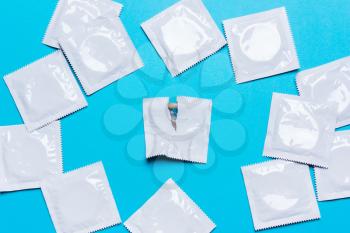Condom on a blue background. The concept of safe sex, stop infection of sexually transmitted diseases,STD, AIDS. 