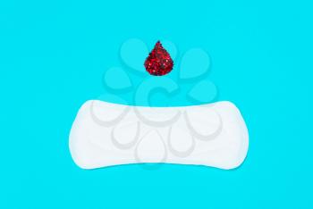 menstrual pads with a drop of blood on a blue background. Concept of critical days,  cycle, menstruation