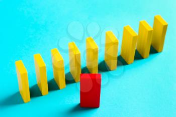 The concept of leadership, individuality. Red domino on yellow background