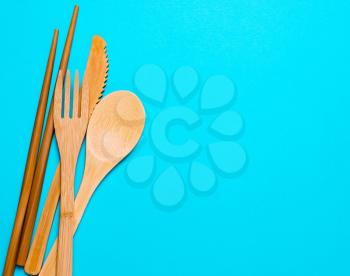 Natural, ecological, Organic wooden fork, spoon, cutlery on a blue background. Concept zero waste, environmental pollution.