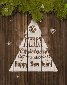Christmas Greeting Card. Inscription with Christmas and new year 2017 against wooden texture and branches of a New Years tree Christmas.