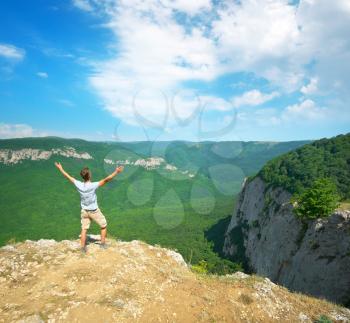 Man in mountain at day strive hands to sun. Enjoy nature scene. 