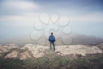 Man in fog in mountain looking to infinity. Conceptual scene.