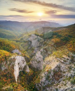 Autumn mountain view with sunshine and haze into canyon. Panorama landscape.