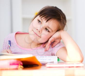 Cute girl writes a pen - concept school education