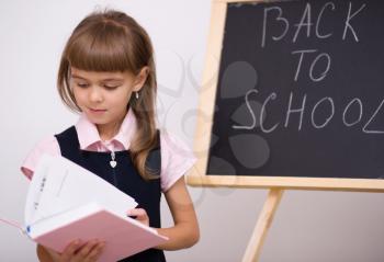 Cute girl is holding book - school concept