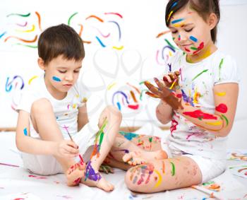 Cute boy and girl showing her hands painted in bright colors