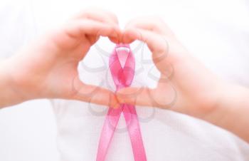 healthcare and medicine concept - girl hands holding pink breast cancer awareness ribbon