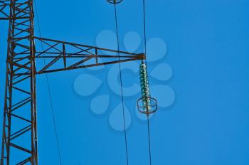 High-voltage tower. Electric powerlines on the blue sky.