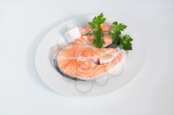 Fresh trout on the white plate, served with parsley closeup