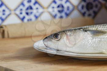 Mullet striped mullet contains omega-3 acids, vitamins and minerals. Mullet lying on the plate ready for cooking. A dietary product. Useful to reduce blood pressure.