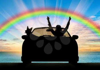 Travel and freedom. Happy man in the car with the dog on the sea sunset and rainbow