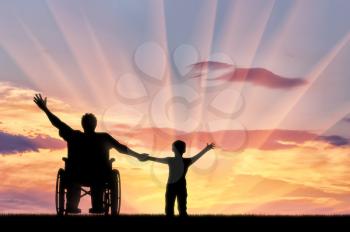 Happy disabled person in wheelchair hold son for hand and they happy on sunset.Concept happy disabled and family
