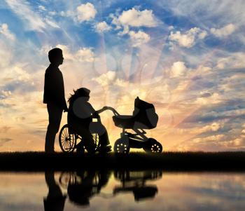 Disabled woman in wheelchair holding baby carriage and beside her husband and reflection in water. Concept disabled and family