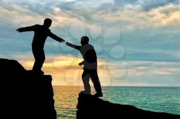 Man gives helping hand to friend over gorge day. Concept helping hand