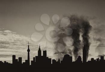 Silhouette of the city in a smoke on a background of beautiful sky