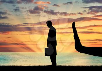 Discrimination and racism concept. Silhouettes of hands stops a man on a background of sea sunset