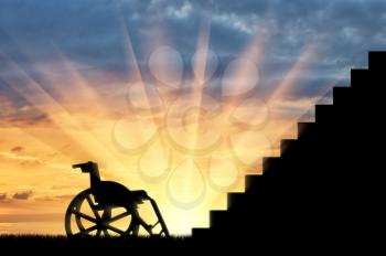 Wheelchair in front of stair sunset. Concept of disability