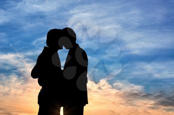 Concept of gay people. Silhouette happy gay kissing against the evening sky